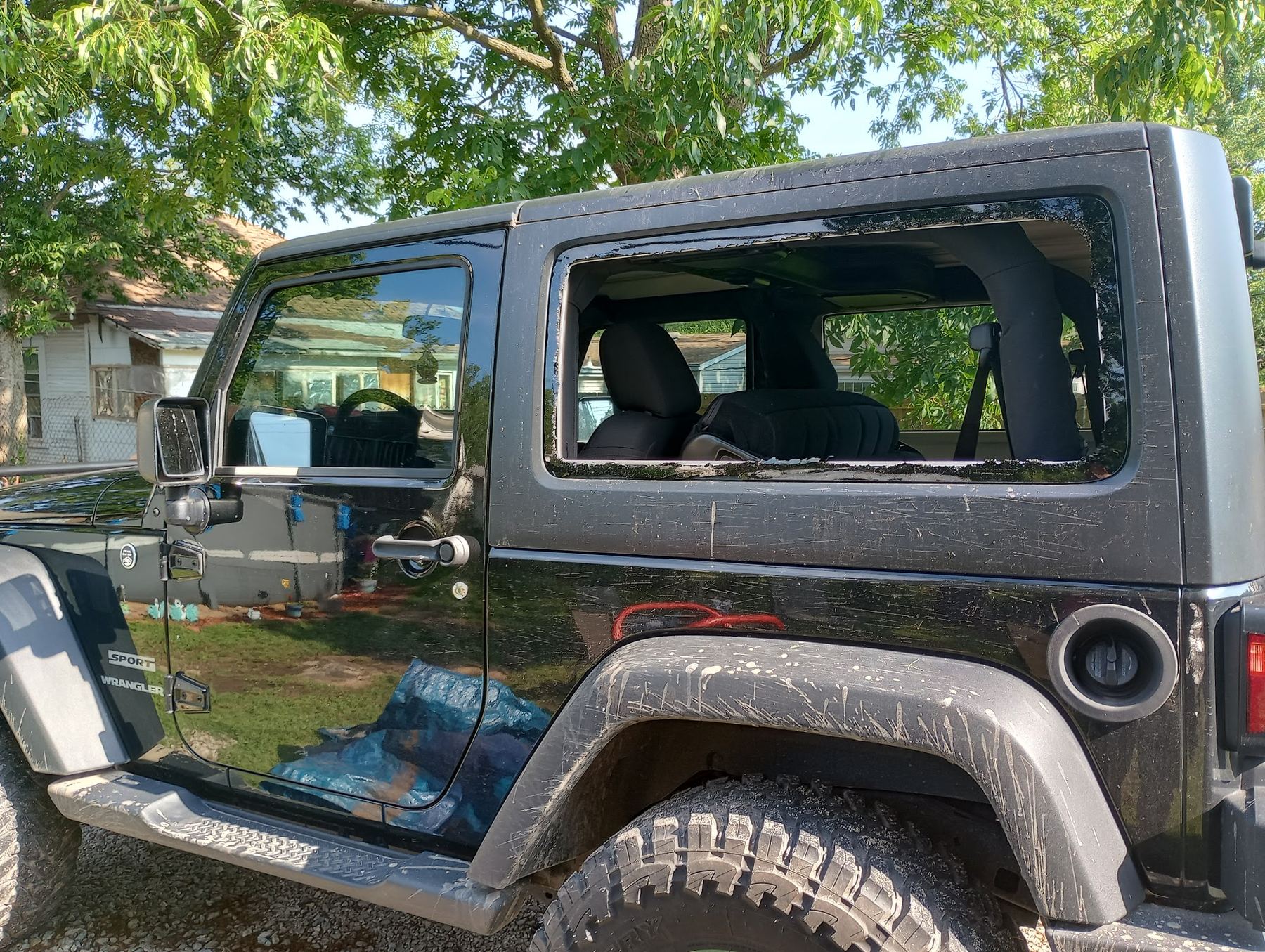 Black Jeep Wrangler mid-job with the rear side glass out