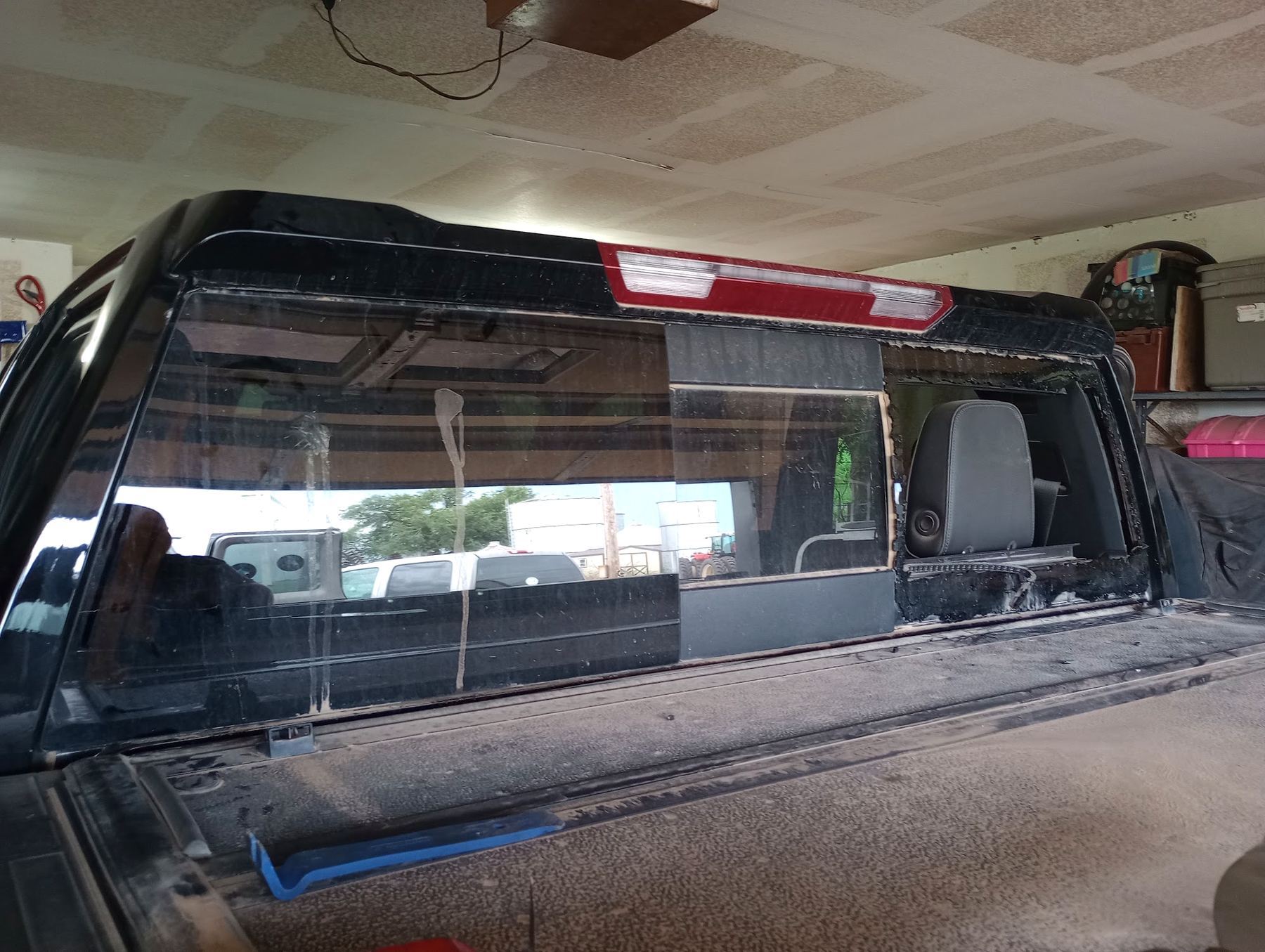 Black pickup in a garage with the rear slider out and the opening prepped